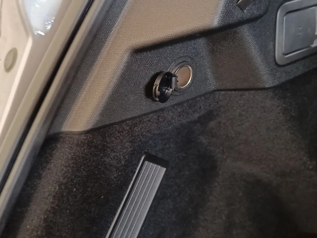 Détail de la prise de charge latérale arrière dans le coffre du DS7 Crossback E-TENSE gris clair, vue rapprochée.