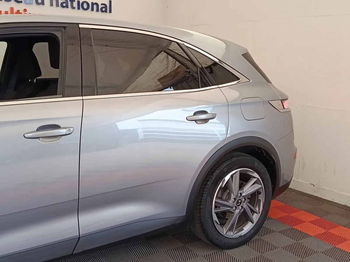 Vue latérale droite du DS7 Crossback E-TENSE 225 Business gris clair, mettant en valeur les jantes alliage et les vitres teintées.