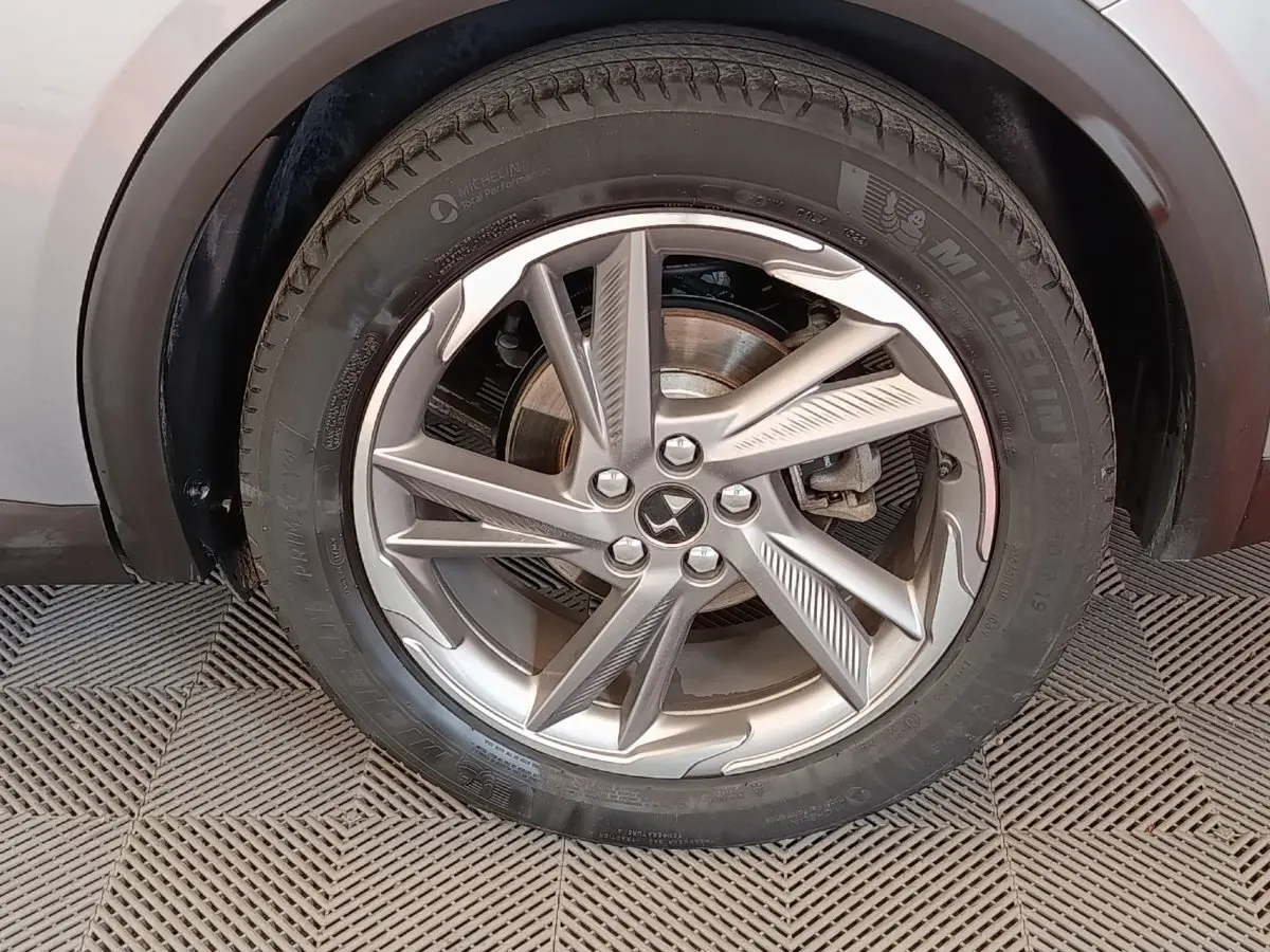 Gros plan sur la roue avant droite gris clair du DS7 Crossback E-TENSE 225 avec jante alliage au design moderne.