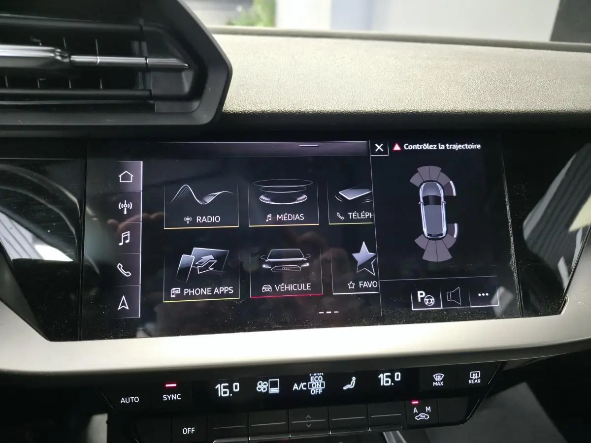 Écran tactile central de l’Audi A3 Sportback 2023 noir, affichant les options multimédias et assistance à la conduite.