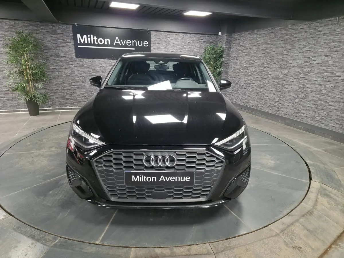 Vue avant d'une Audi A3 Sportback noire 2023 avec calandre hexagonale et phares LED dynamiques.