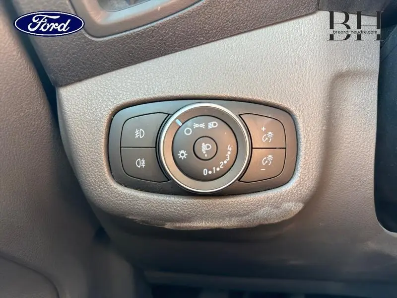 Gros plan sur le bouton de commande des phares du Ford Transit Connect blanc glacier, intérieur côté conducteur.