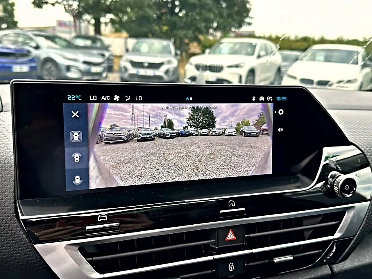 Écran tactile intérieur de Citroën C4 gris 2024 montrant la caméra de recul avec vue arrière sur parking.