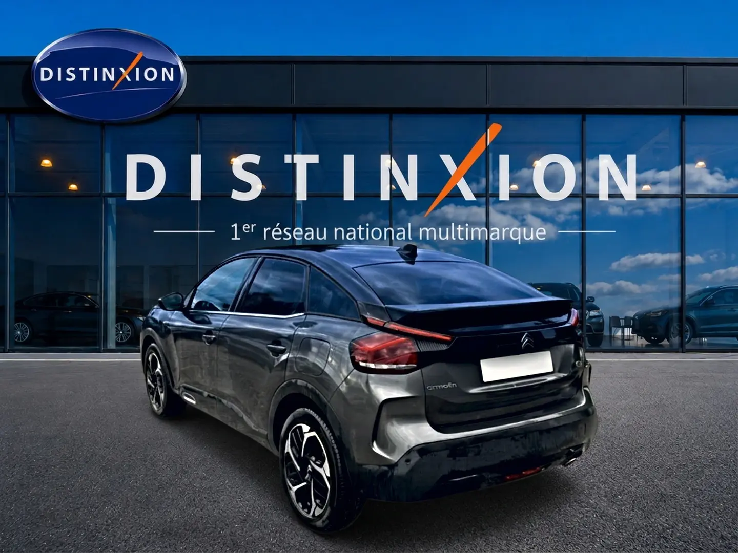 Vue 3/4 arrière droite d'une Citroën C4 gris métallisé 2024, avec jantes alu et feux arrière LED distinctifs.