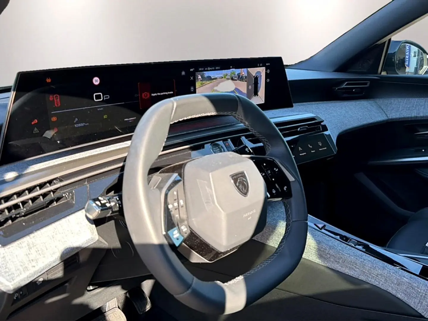 Vue intérieure côté conducteur du Peugeot 3008 1.2 hybrid 145 allure 2025, volant cuir et tableau de bord numérique.