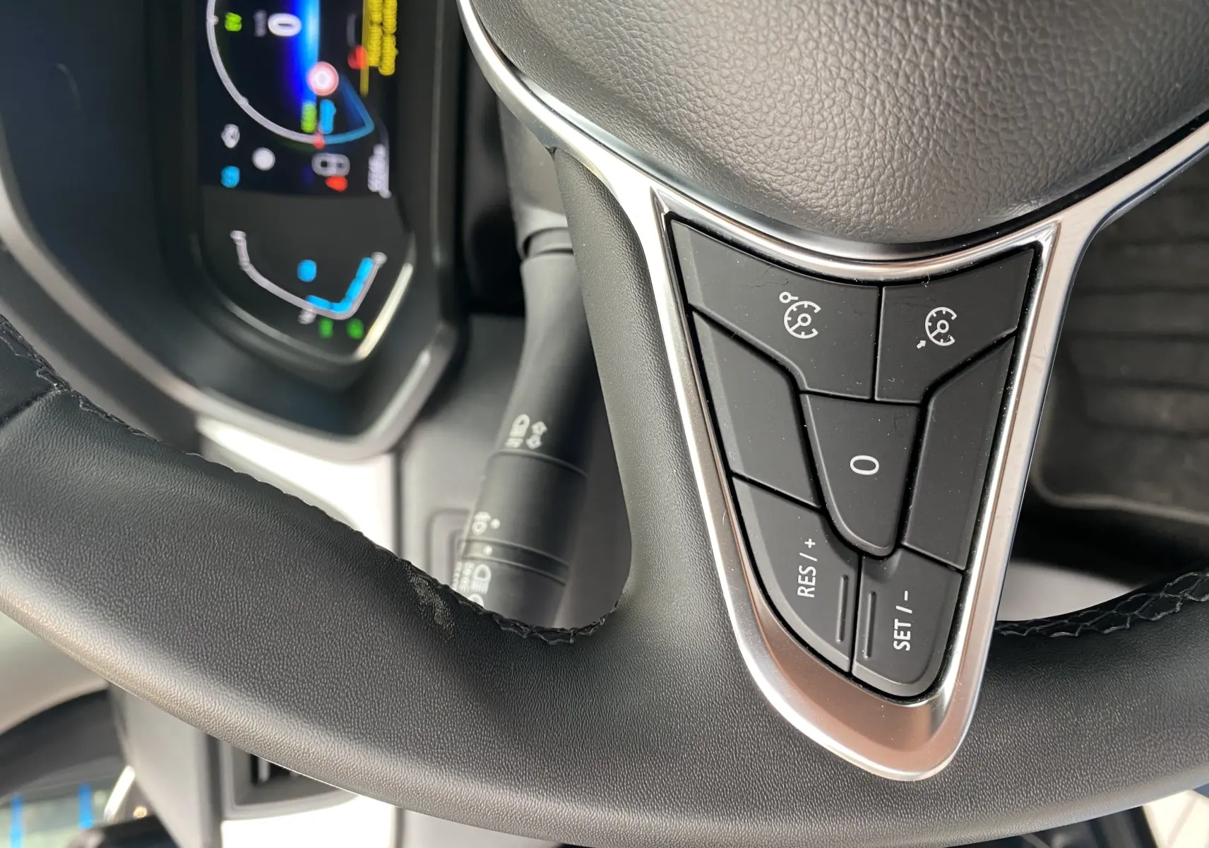 Gros plan sur les commandes au volant du Mitsubishi ASX 2023 gris Steel Gray, affichage numérique en arrière-plan.