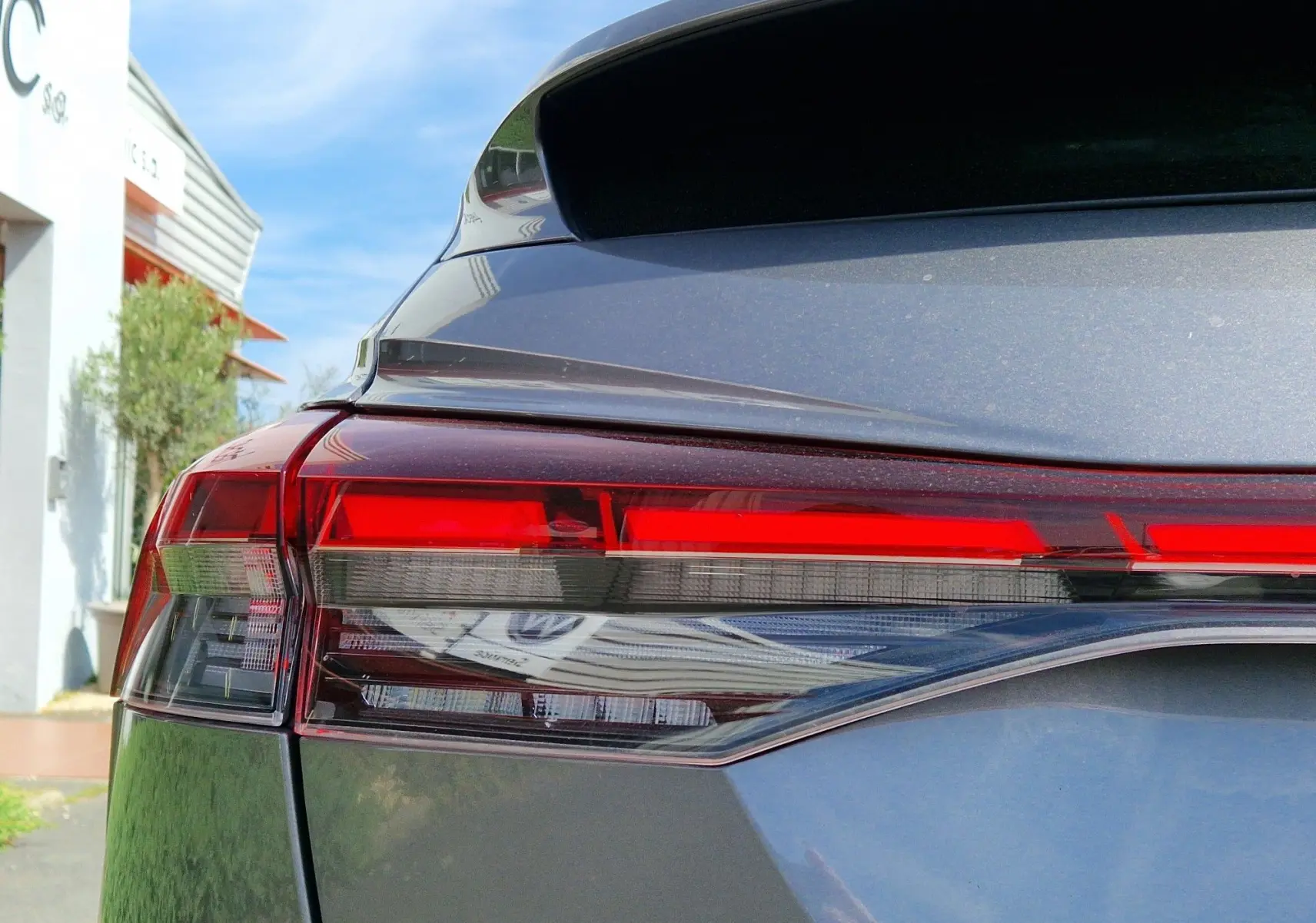 Gros plan sur le feu arrière droit rouge du SUV électrique Audi Q4 E-TRON Sportback gris thyphon 2022.