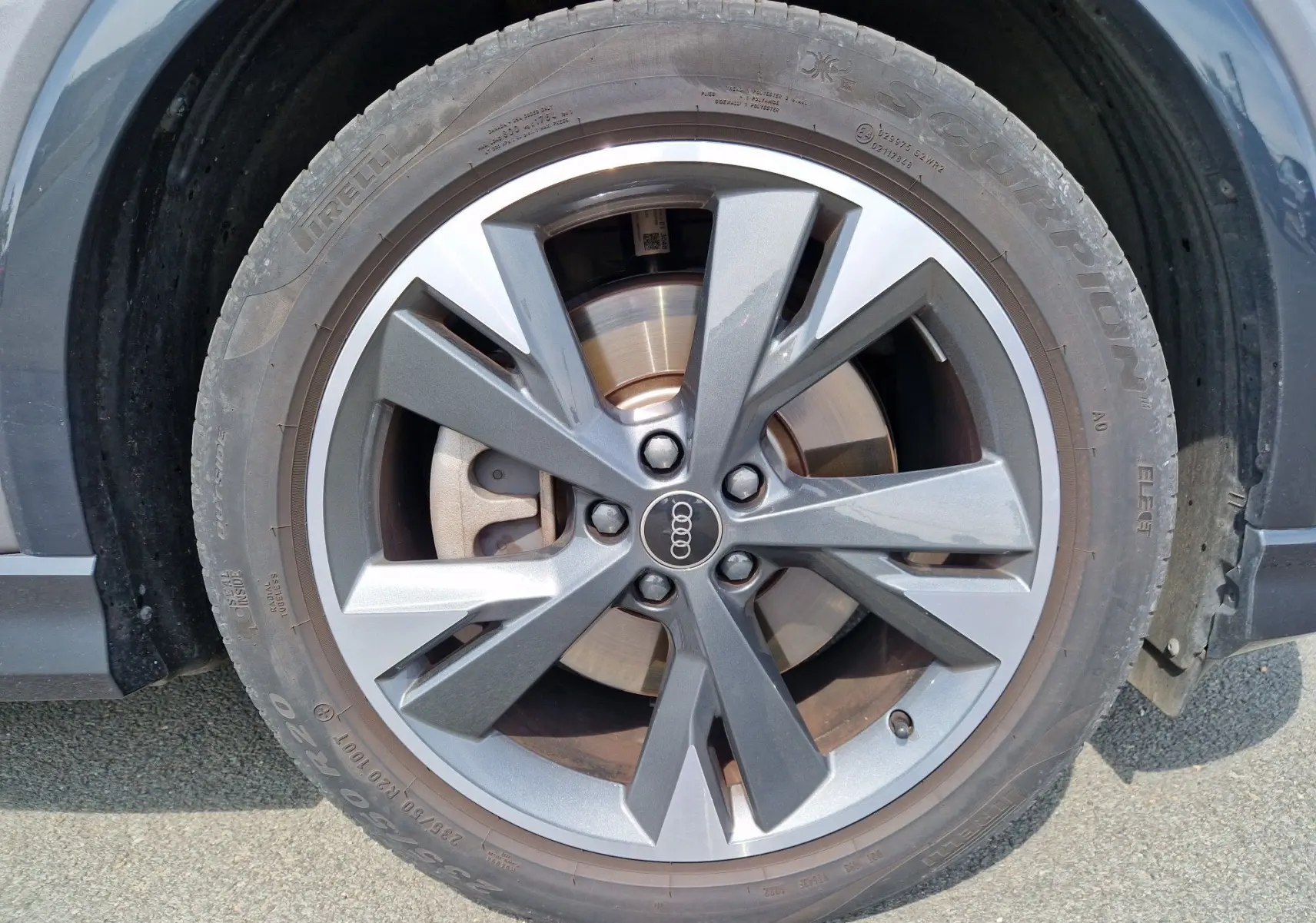 Gros plan sur la roue avant droite de l'Audi Q4 E-TRON Sportback gris thyphon avec jante en alliage à design moderne.