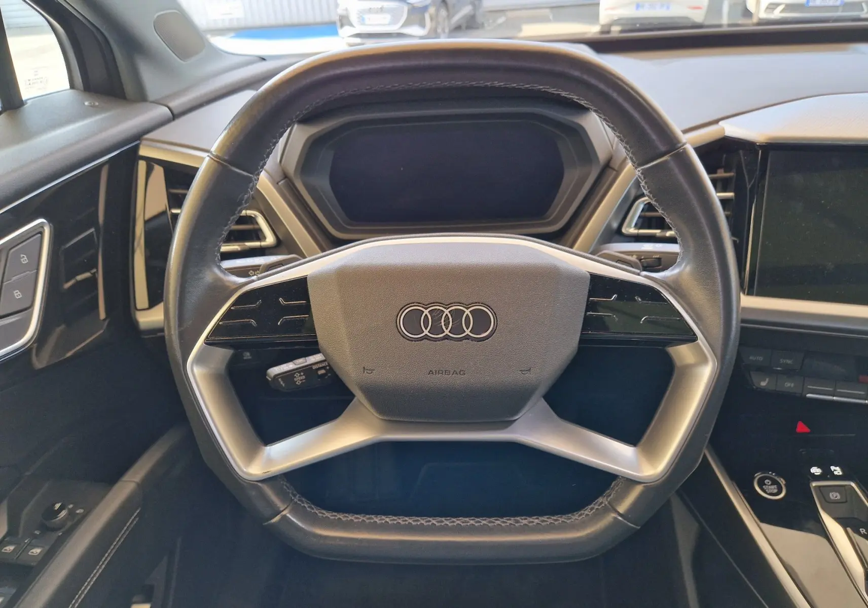 Volant multifonction en cuir noir de l'Audi Q4 E-TRON SPORTBACK 50 quattro, vue frontale de l'habitacle moderne.