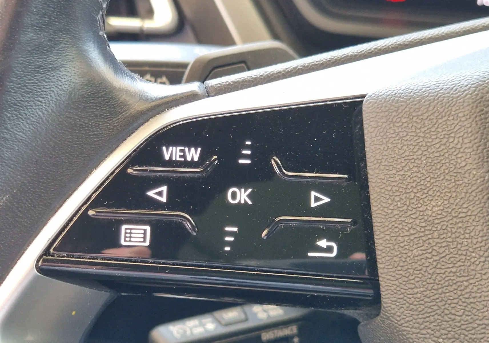 Gros plan sur les commandes tactiles du volant noir de l'Audi Q4 E-TRON Sportback gris thyphon.