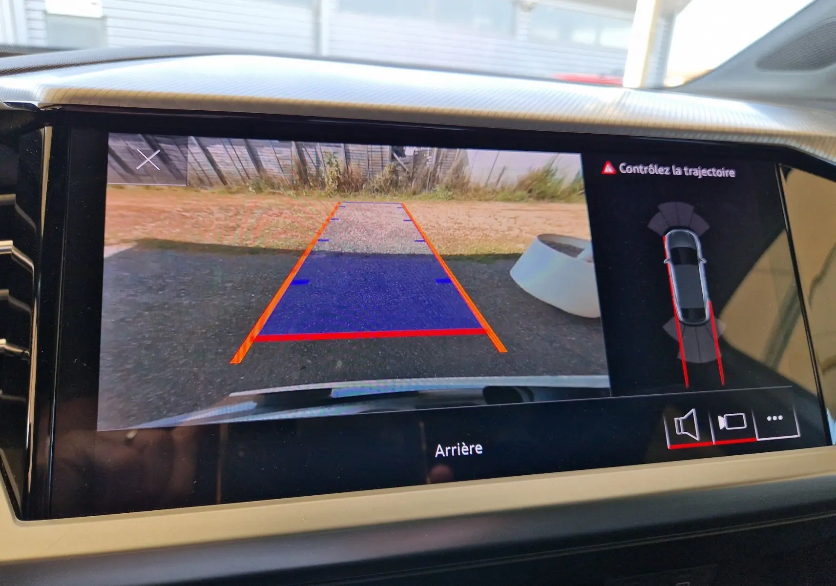 Vue de l'écran de recul de l'Audi Q4 E-TRON Sportback gris thyphon, affichant les lignes de guidage et l'alerte de trajectoire.