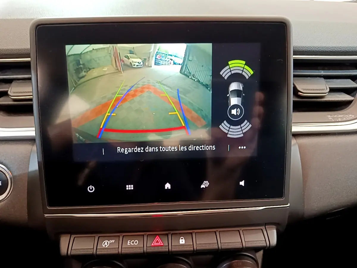 Écran tactile intérieur du Renault Captur noir montrant la caméra de recul avec guidage et capteurs de stationnement actifs.