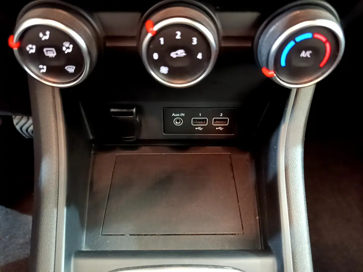 Gros plan sur les commandes de climatisation et ports USB du Renault Captur Business noir, vue intérieure centrale.