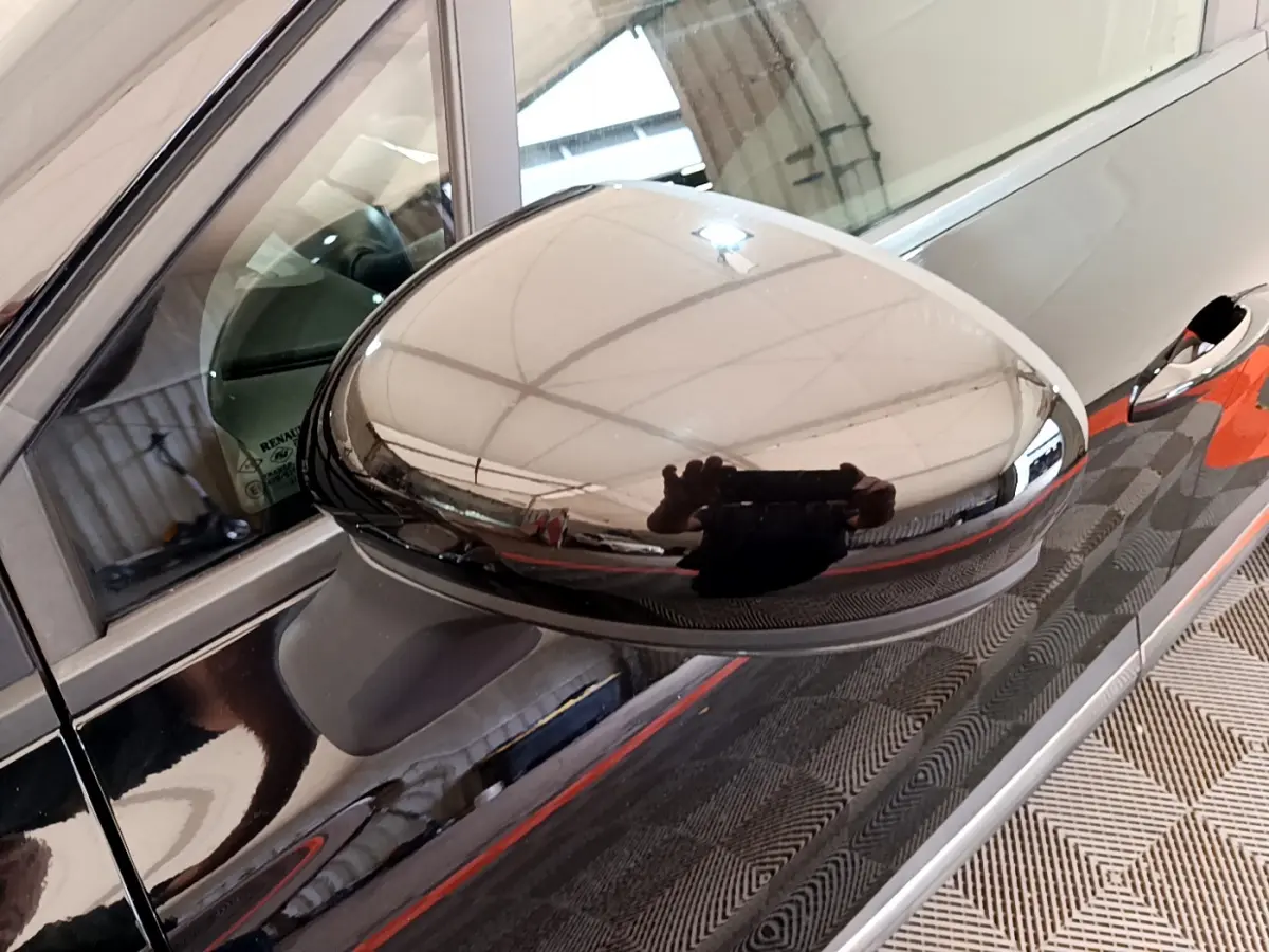 Rétroviseur côté gauche noir brillant du Renault Captur Business Blue dCi 95, reflet d'un intérieur lumineux.