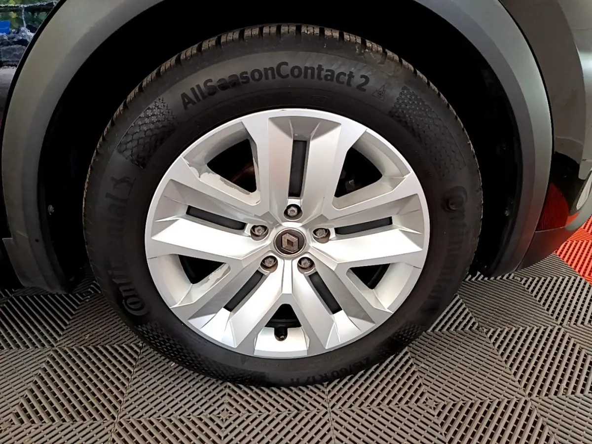 Gros plan sur la roue avant droite d’un Renault Captur noir de 2020 avec jante argentée et pneu Continental AllSeasonContact 2.