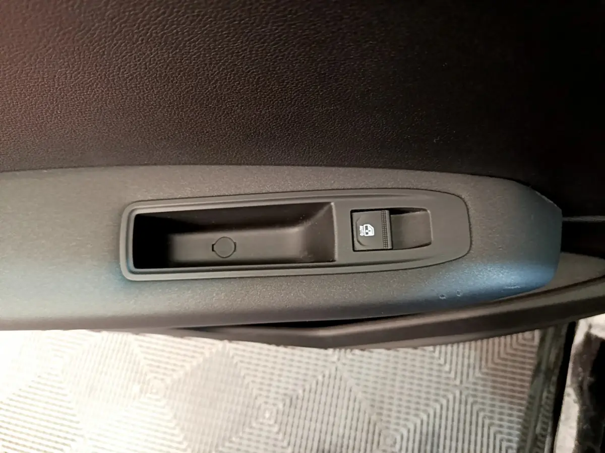 Gros plan sur le bouton de verrouillage des vitres sur la porte intérieure noire d'un Renault Captur Business 2020.