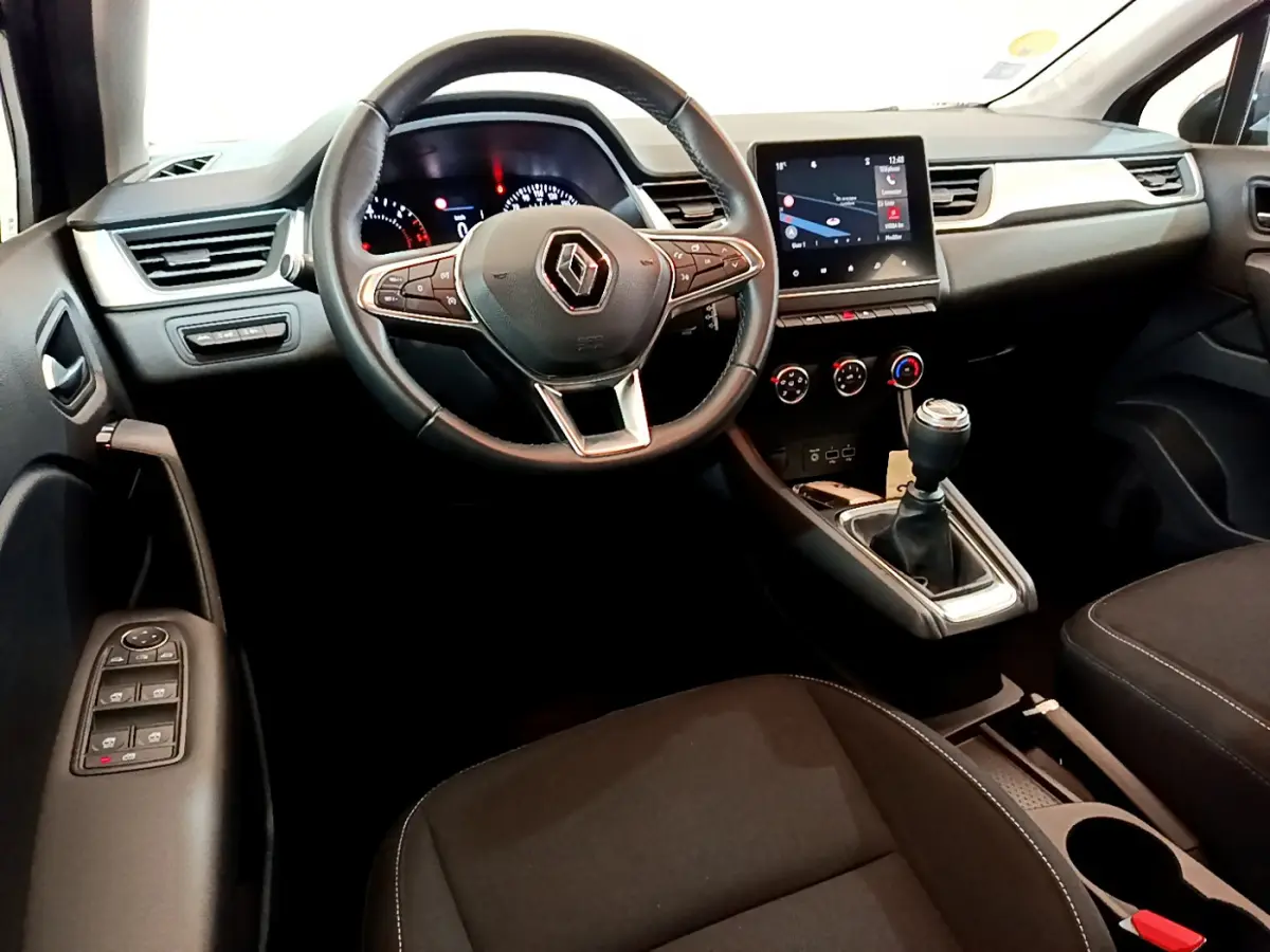 Intérieur noir du Renault Captur Business Blue dCi 95, vue avant centrée sur volant et console avec écran tactile.