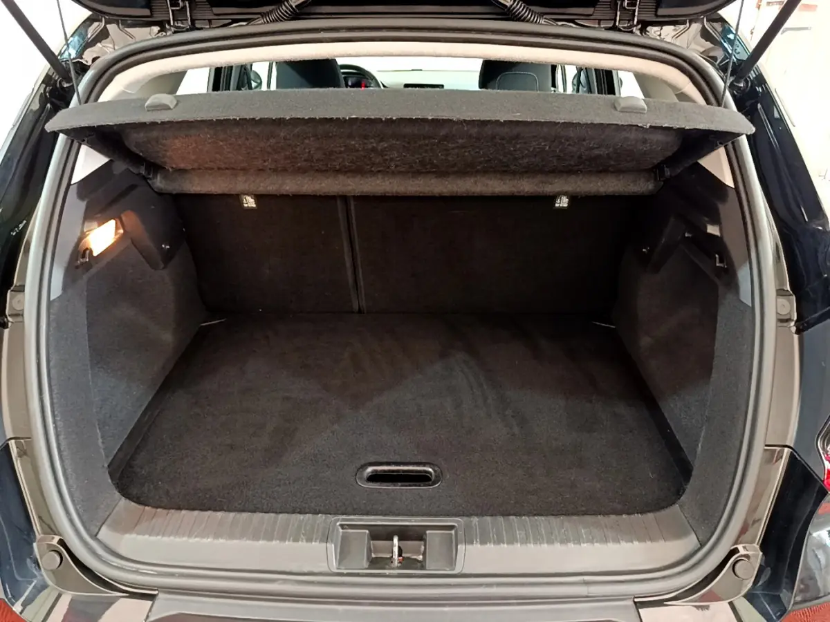 Coffre ouvert d'un Renault Captur noir 2020, vue arrière montrant l'espace de chargement vide et la tablette cache-bagages relevée.