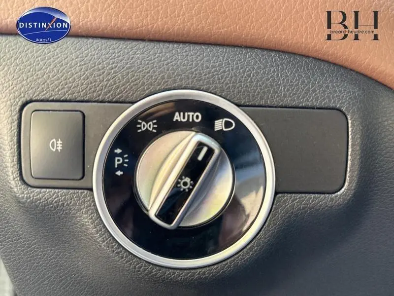 Gros plan sur la commande des phares d’un Mercedes Classe A 220 CDI Business Executive gris, avec bouton rotatif en position AUTO.