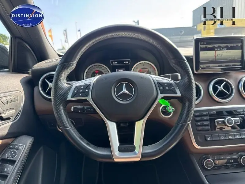 Vue centrée sur le volant cuir d'une Mercedes Classe A 220 CDI Business Executive, avec tableau de bord et écran multifonction visibles.