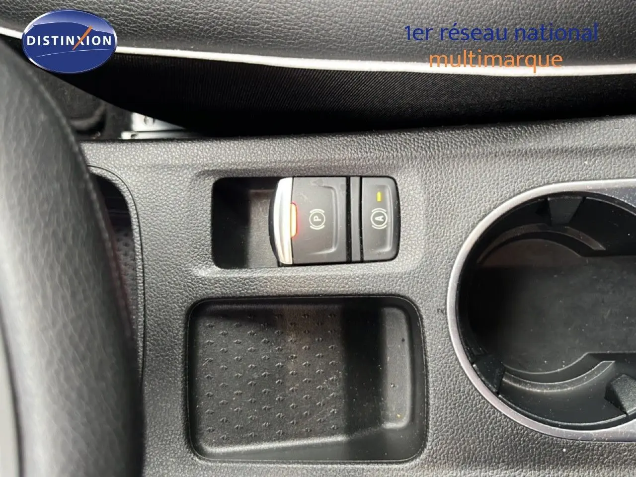 Gros plan sur la console centrale du Renault Captur 2021, montrant les boutons de frein à main électrique et arrêt/marche auto.