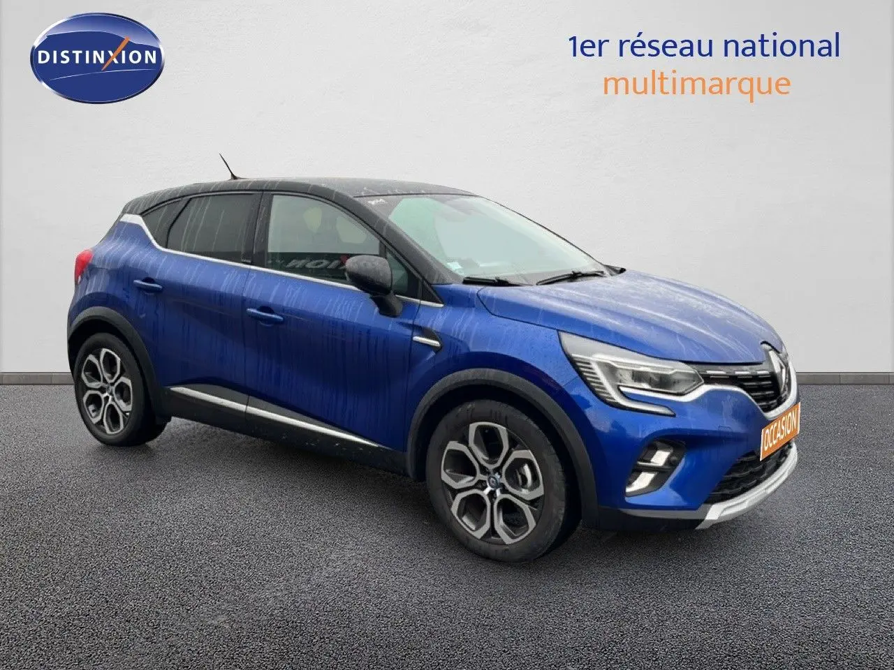 Renault Captur 1.6 E-Tech hybride rechargeable bleu Iron métal avec toit noir, vue 3/4 avant droit sur fond neutre.