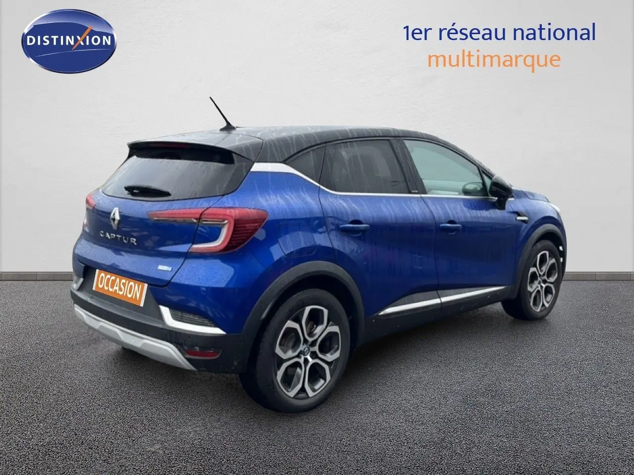 Vue 3/4 arrière droite d'un Renault Captur bleu Iron Metal avec toit noir, roues alliage et feux LED distinctifs.