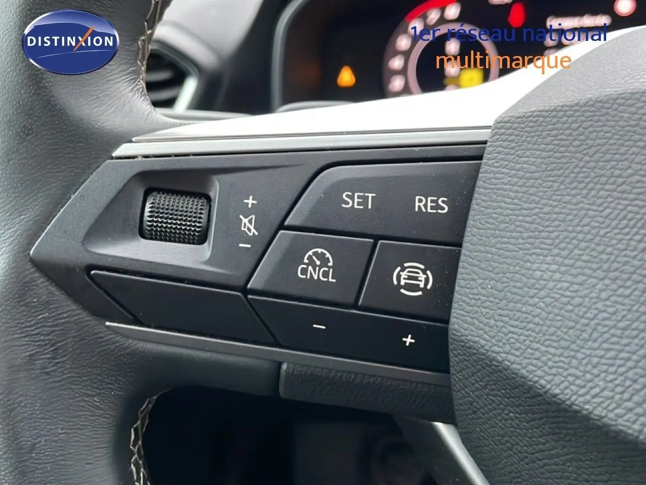 Gros plan sur les commandes au volant du SEAT LEON ST bleu Fjord, version 2025, mettant en valeur les boutons de régulateur de vitesse.