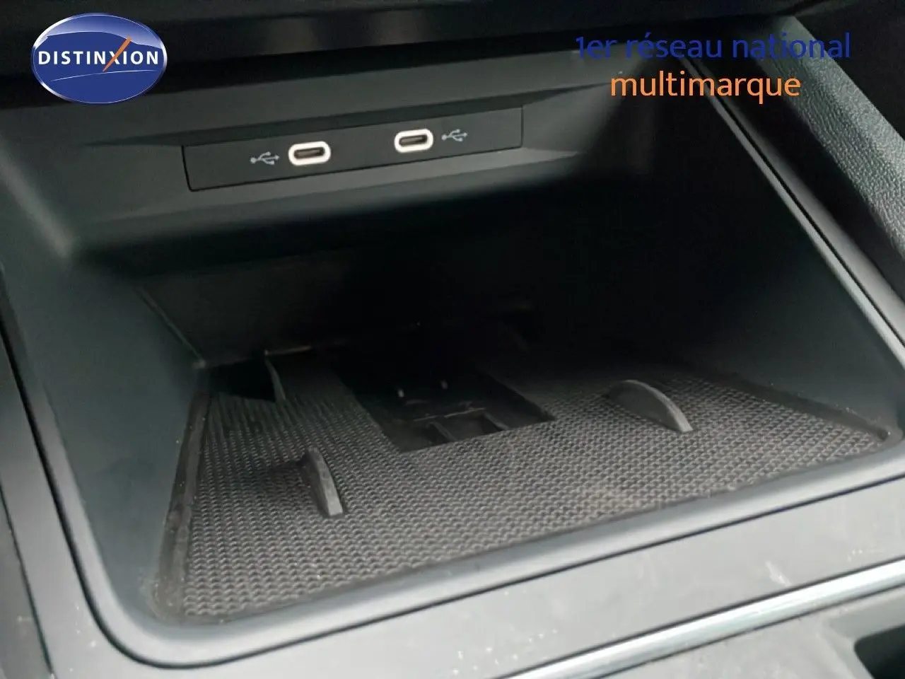 Gros plan sur le compartiment de rangement intérieur avec deux ports USB visibles dans une SEAT Leon ST bleu Fjord.