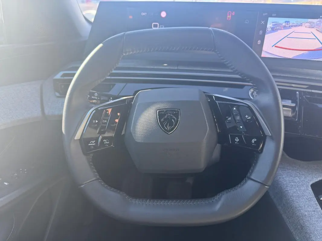 Vue frontale du volant cuir noir du Peugeot 3008 Hybrid 145 e-DCS6 Allure 2025 avec commandes intégrées et tableau de bord numérique.