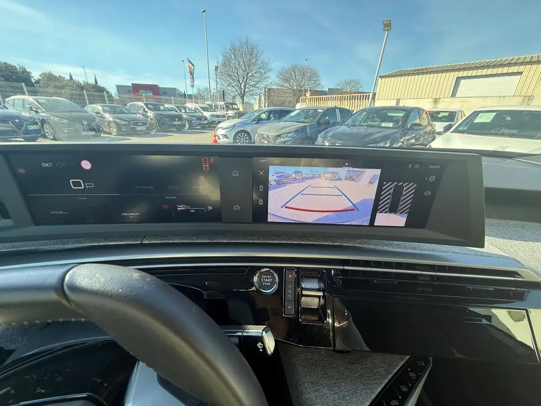 Vue intérieure du cockpit numérique du Peugeot 3008 Hybrid 145 Allure 2025, avec affichage caméra de recul et volant partiel.