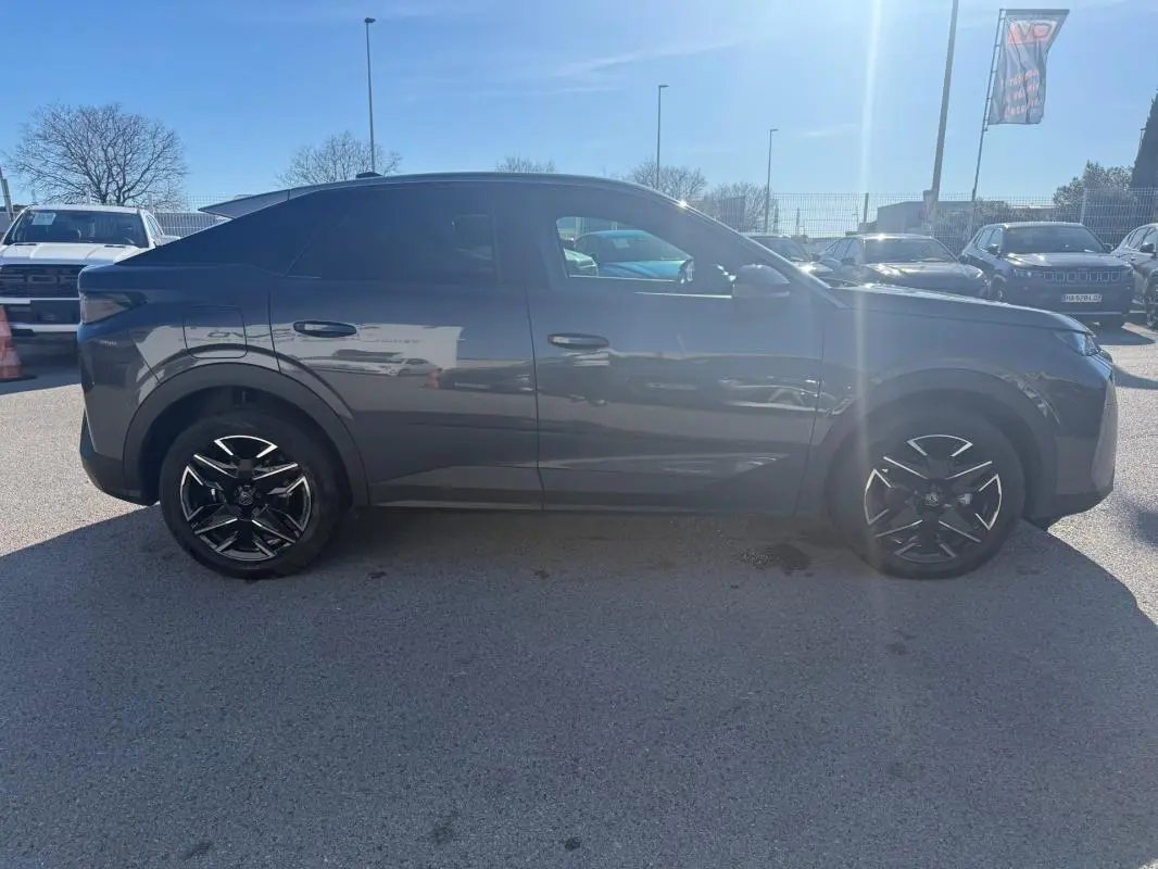 Peugeot 3008 Hybrid gris vue de profil côté gauche, avec jantes alliage noires 19 pouces sous un ciel ensoleillé.
