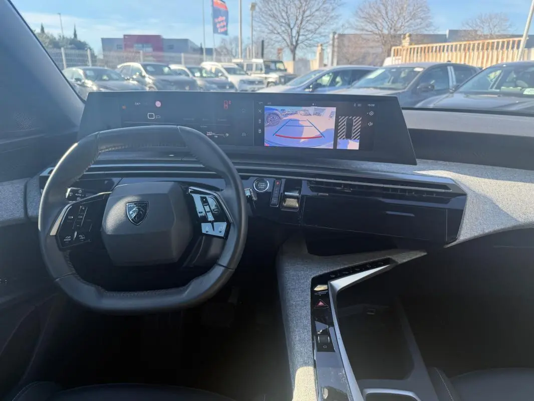 Vue intérieure du tableau de bord gris du Peugeot 3008 Hybrid 145 e-DCS6 Allure avec volant compact et écran numérique large.