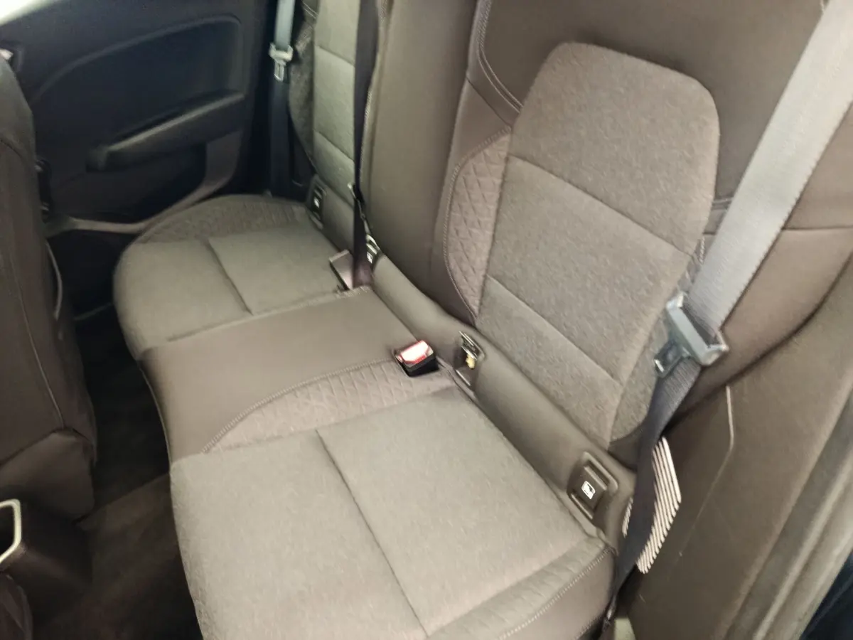 Vue rapprochée de la banquette arrière gris foncé de la Renault Clio Business E-TECH 140, avec ceinture de sécurité visible.