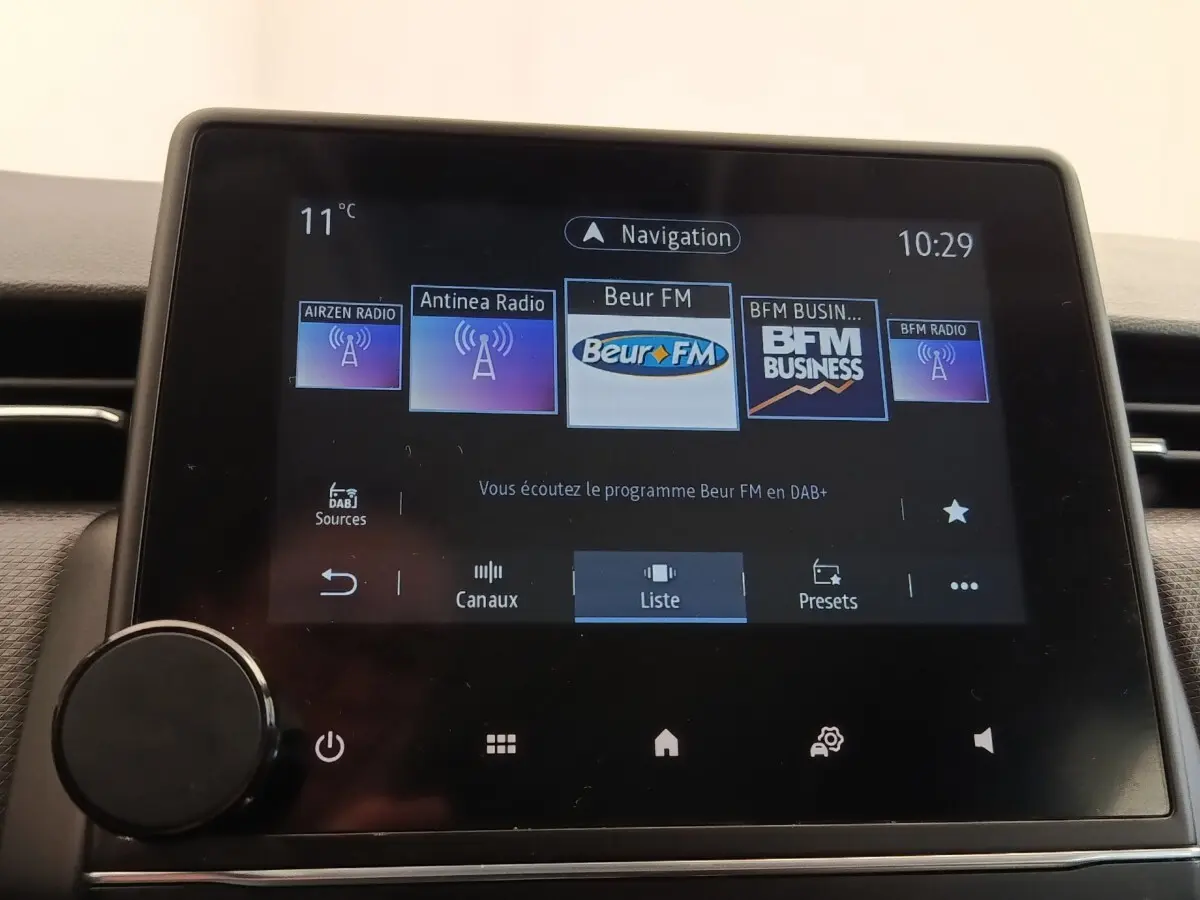 Écran tactile central de la Renault Clio Business E-TECH 140 affichant les stations radio numériques.