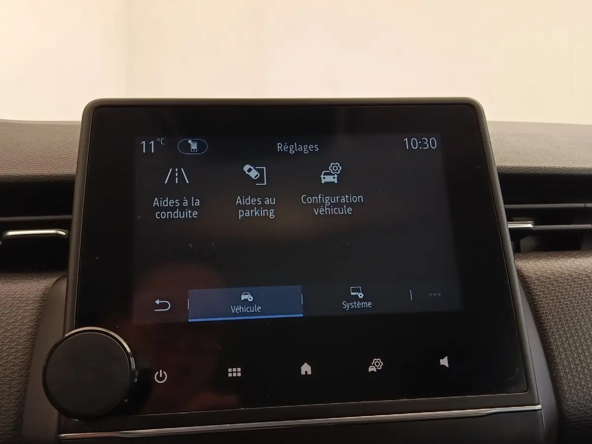 Écran tactile central de la Renault Clio Business E-TECH 140 affichant les réglages d’aides à la conduite et au parking.