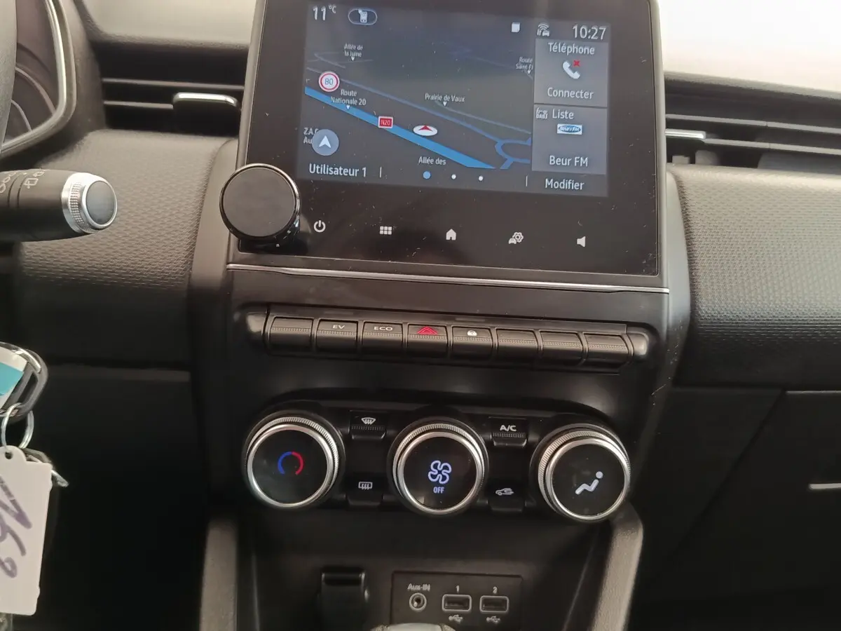 Vue rapprochée du tableau de bord central noir de la Renault Clio Business E-TECH 140 avec écran tactile et commandes de climatisation.
