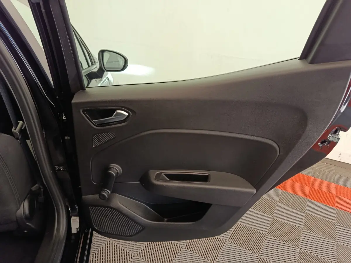 Vue intérieure de la porte arrière gauche noire de la Renault Clio Business E-TECH 140, avec poignée manuelle de vitre.
