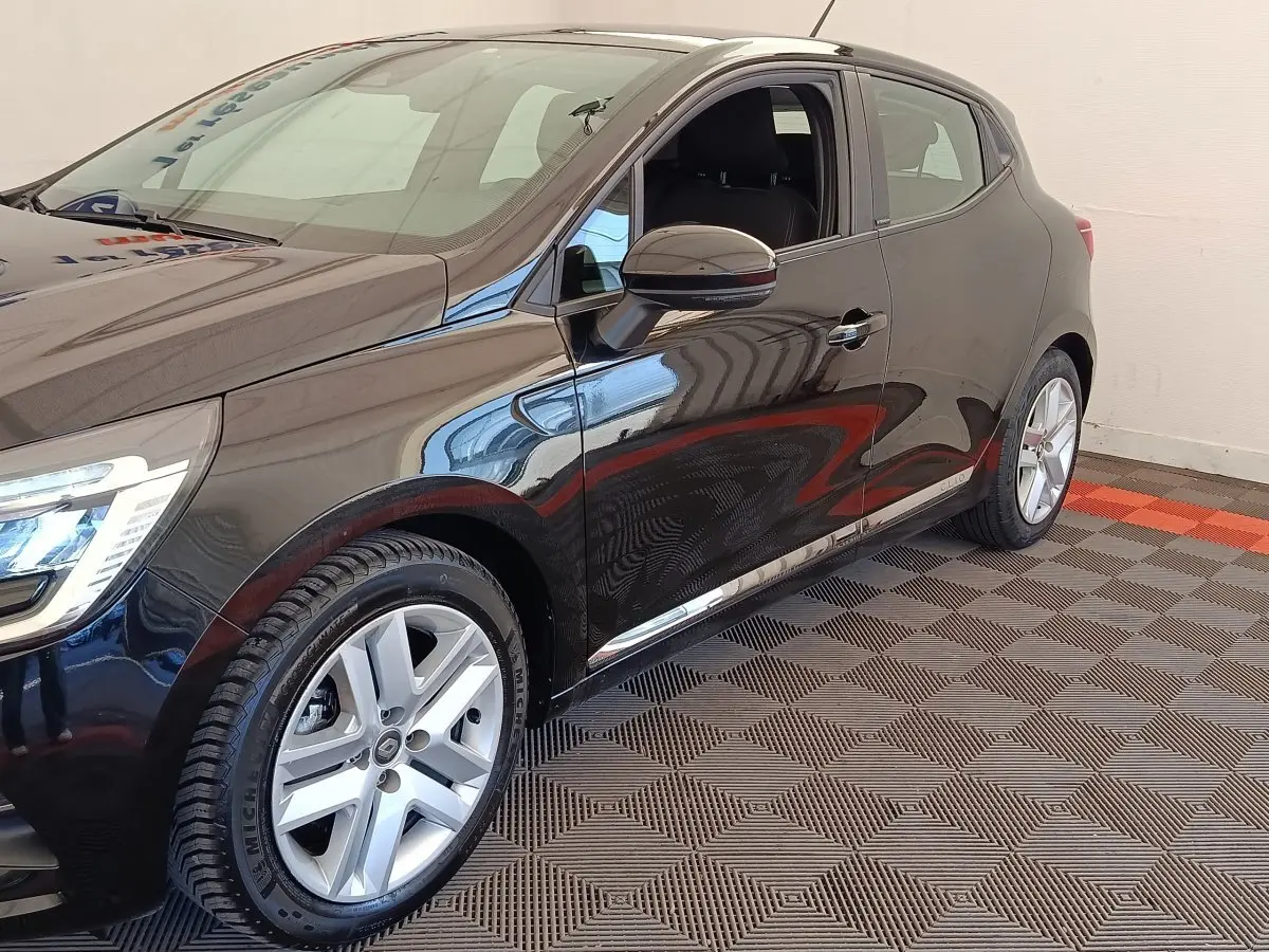 Vue de profil côté gauche d'une Renault Clio Business E-TECH 140 noire avec jantes alliage et rétroviseurs chromés.
