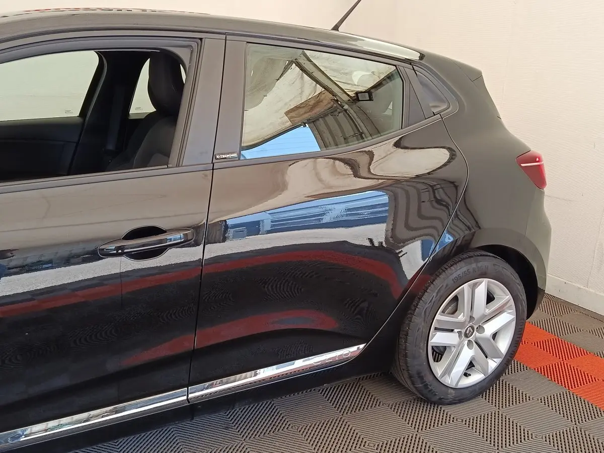 Vue de profil côté gauche d'une Renault Clio Business E-TECH 140 noire avec jantes alliage et poignées intégrées.