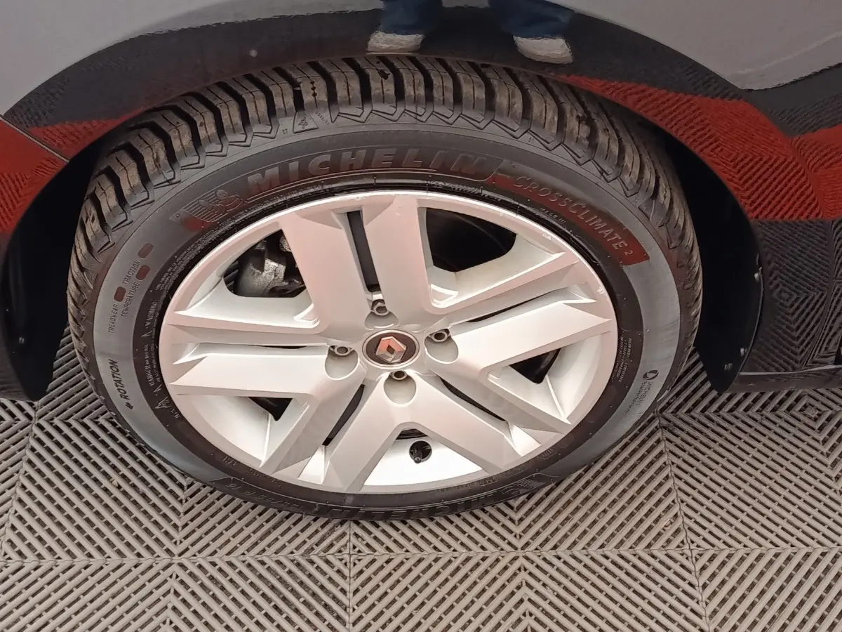 Gros plan sur la roue avant droite de la Renault Clio blanche, mettant en valeur la jante alliage et le pneu Michelin.