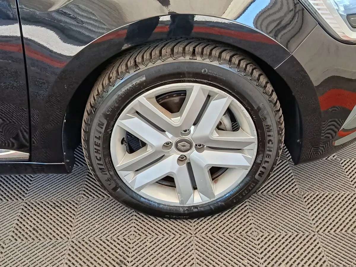 Gros plan sur la roue avant droite d’une Renault Clio noire, avec jante alliage et pneu Michelin visible.