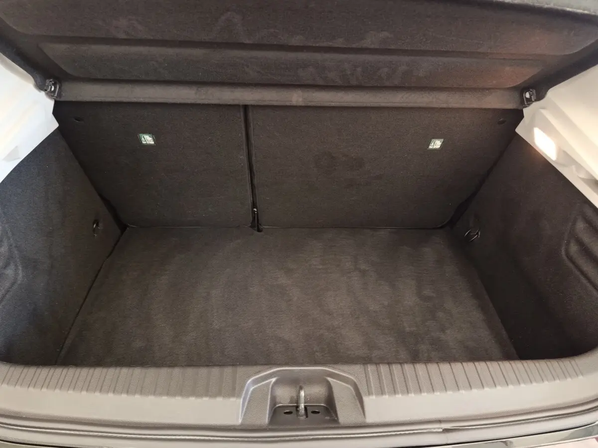 Coffre ouvert vu de dessus d’une Renault Clio Business E-TECH 140 blanche, intérieur noir et espace de rangement vide.