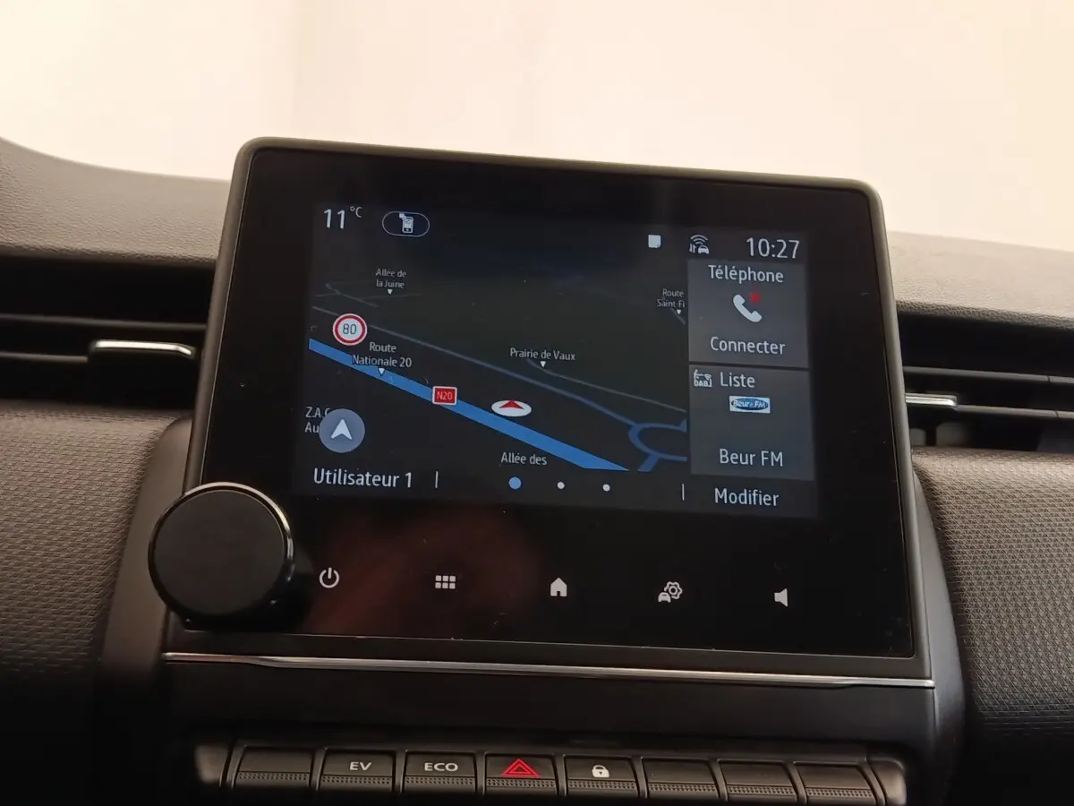 Écran tactile central de navigation et multimédia dans le tableau de bord d'une Renault Clio Business E-TECH blanc, vue intérieure.