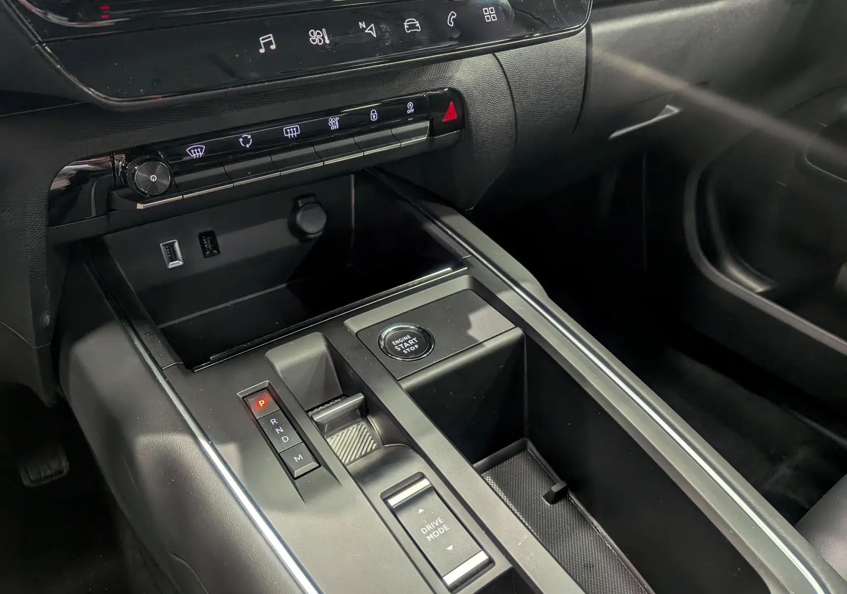 Vue rapprochée de la console centrale noire du Citroën C5 Aircross hybride 2025 avec bouton start/stop et sélecteur de boîte automatique.