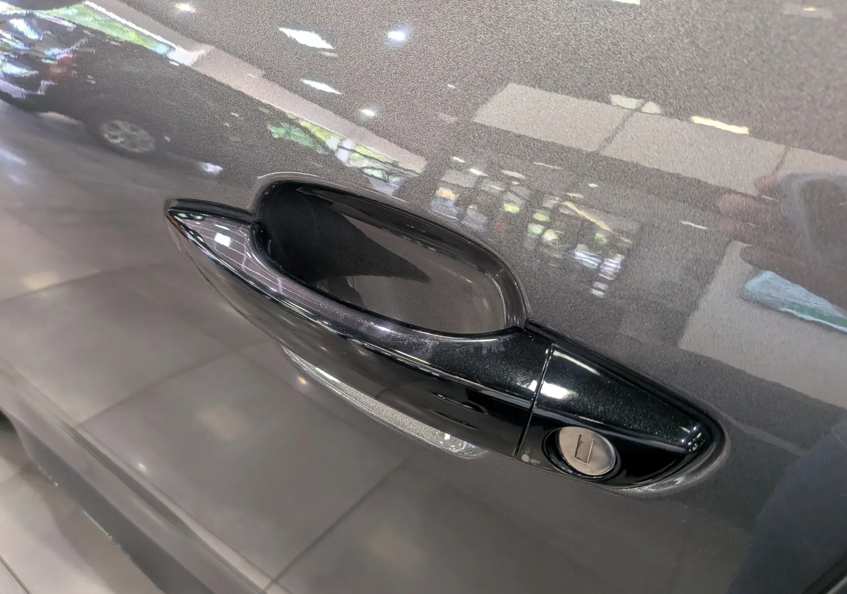 Poignée de porte noire en gros plan sur la porte gris Platinium d'un Citroën C5 Aircross hybride 2025.