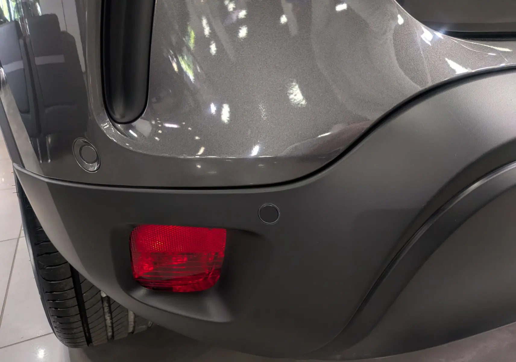 Gros plan sur l'angle arrière droit du Citroën C5 Aircross gris Platinium, mettant en valeur le feu arrière et le pare-chocs noir.