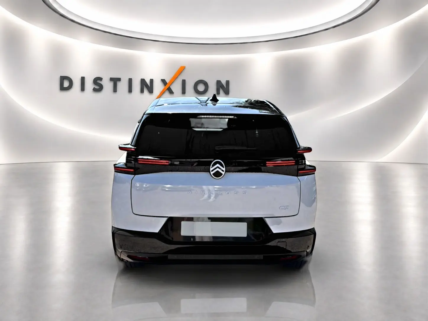 Vue arrière d’un Citroën C5 Aircross blanc et noir avec feux LED, dans un showroom lumineux marqué Distinxion.