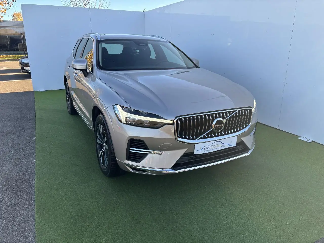 Volvo XC60 T6 Recharge argent crépuscule, vue 3/4 avant droit avec calandre chromée et jantes alliage.