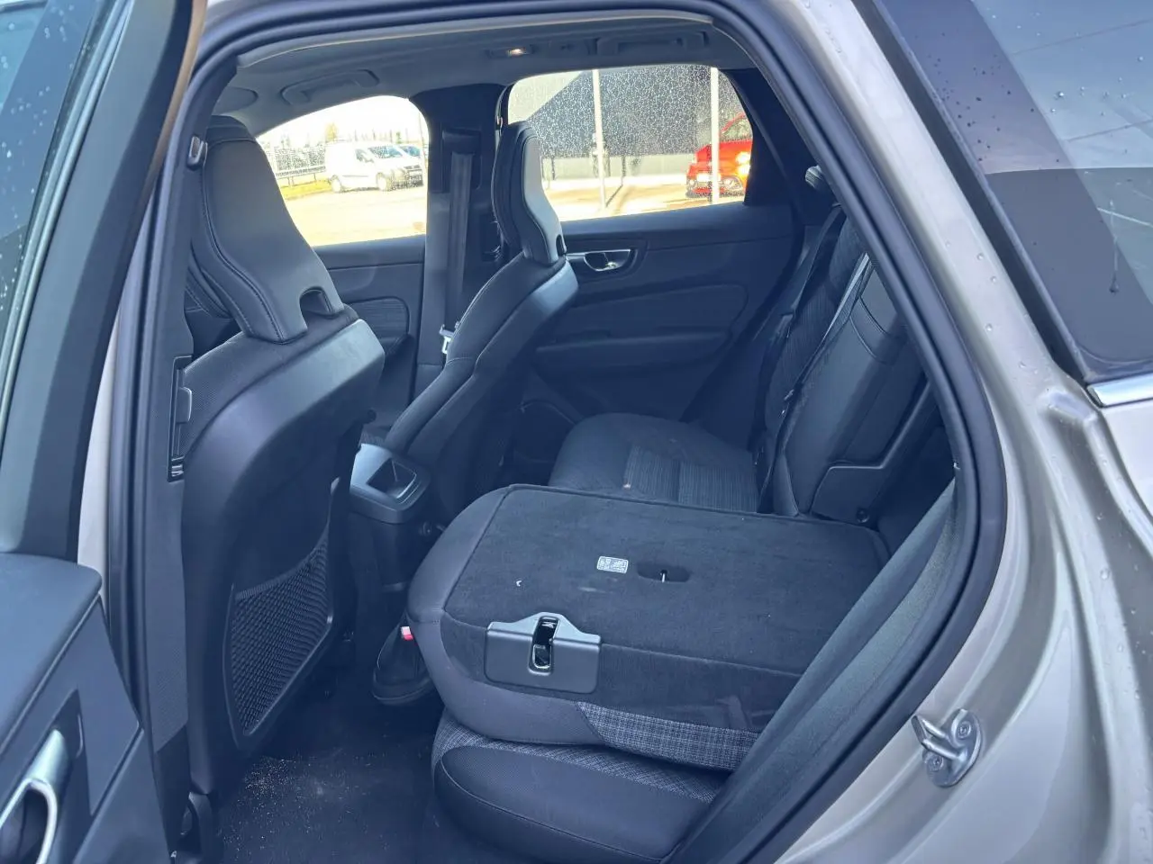 Vue intérieure côté gauche du Volvo XC60 argent crépuscule, siège arrière rabattable et dossier partiellement abaissé.